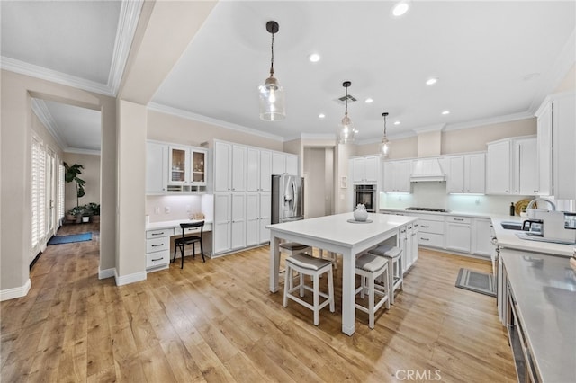 kitchen featuring white cabinetry, a breakfast bar, stainless steel appliances, and a center island