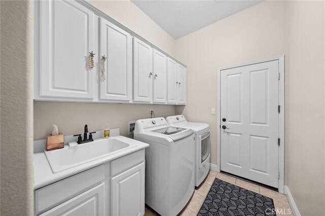 clothes washing area with cabinets, separate washer and dryer, sink, and light tile patterned floors