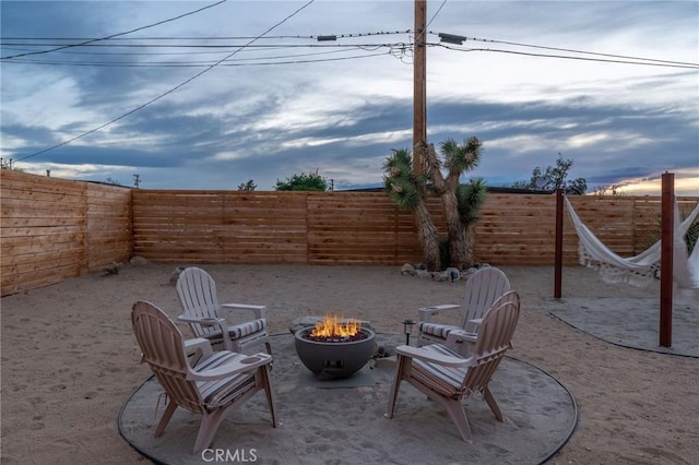 patio terrace at dusk featuring a fire pit