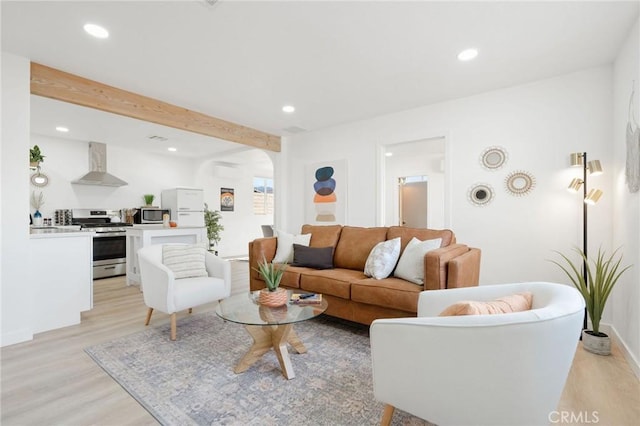 living room with beam ceiling and light wood-type flooring