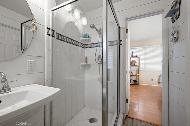 bathroom featuring a shower with shower door, sink, and hardwood / wood-style floors