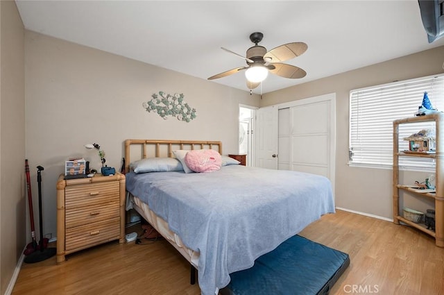 bedroom with light hardwood / wood-style floors, a closet, and ceiling fan