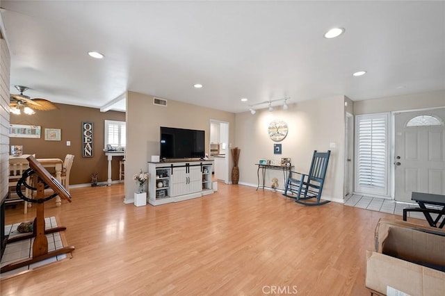 living room featuring light hardwood / wood-style floors and ceiling fan