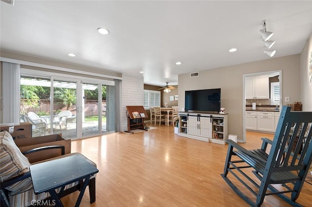 living room with light hardwood / wood-style floors and ceiling fan