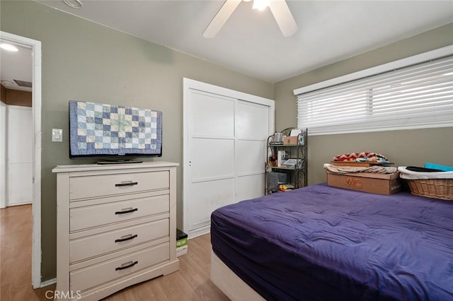 bedroom with a closet, ceiling fan, and light hardwood / wood-style flooring