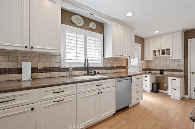 kitchen with sink, backsplash, white cabinets, stainless steel dishwasher, and light wood-type flooring