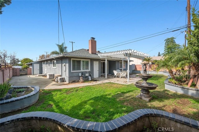 rear view of house with a yard, a pergola, and a patio area