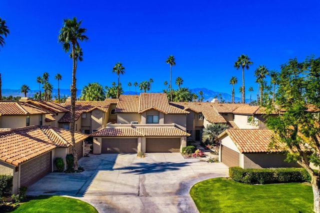 mediterranean / spanish home with a mountain view, a garage, and a front yard