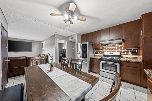 kitchen featuring light tile patterned flooring, appliances with stainless steel finishes, backsplash, dark brown cabinetry, and ceiling fan