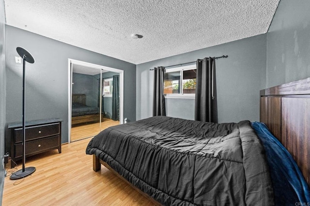 bedroom featuring light hardwood / wood-style floors, a closet, and a textured ceiling