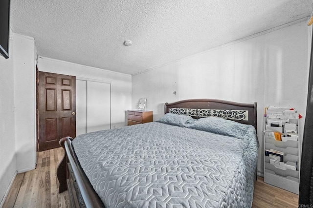 bedroom featuring hardwood / wood-style flooring, a closet, and a textured ceiling