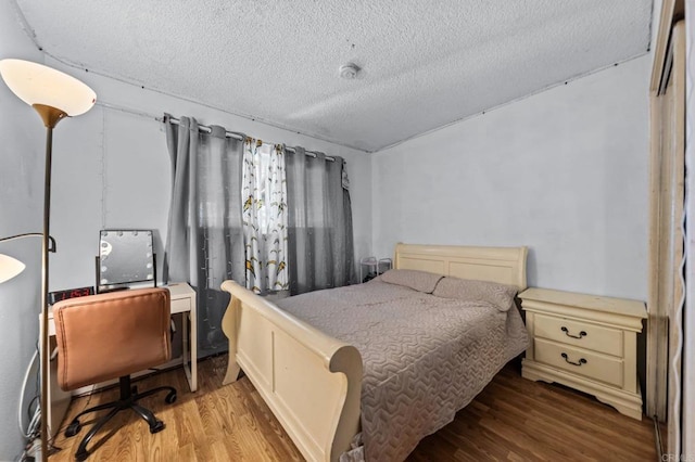 bedroom featuring a textured ceiling and light wood-type flooring