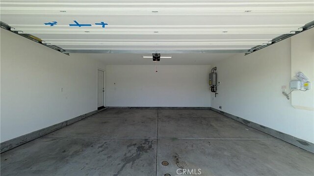 garage with strapped water heater and a garage door opener