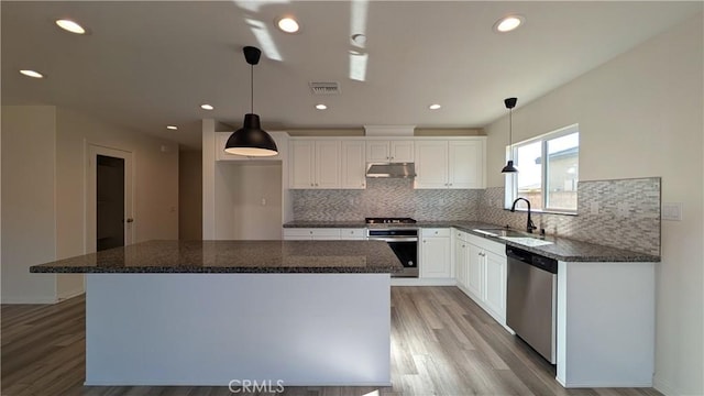 kitchen with a kitchen island, decorative light fixtures, white cabinetry, sink, and stainless steel appliances