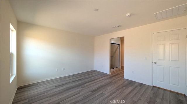 unfurnished bedroom featuring dark hardwood / wood-style flooring and a closet