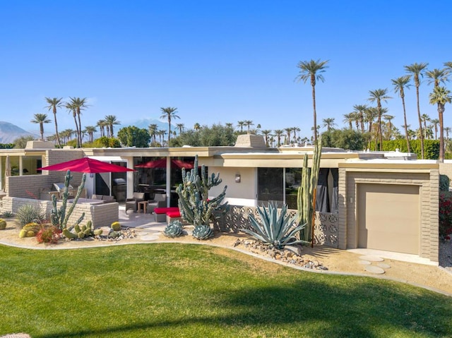 view of front of home with a garage, a patio area, and a front yard