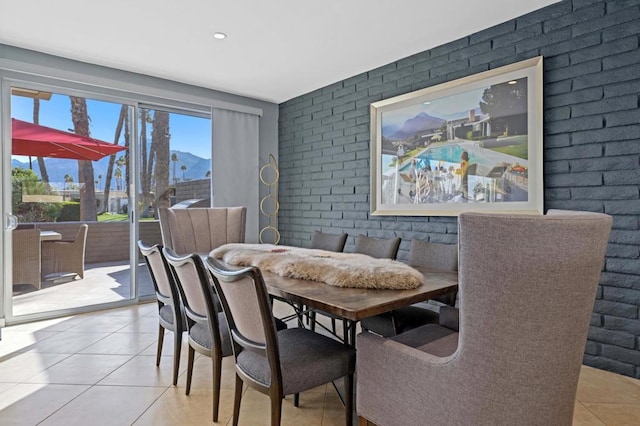 tiled dining space with brick wall and a mountain view