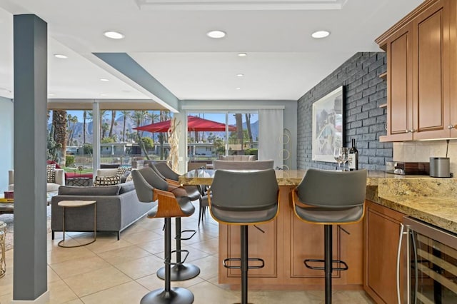 interior space with light tile patterned flooring, beverage cooler, and light stone counters