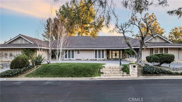 ranch-style home featuring a lawn