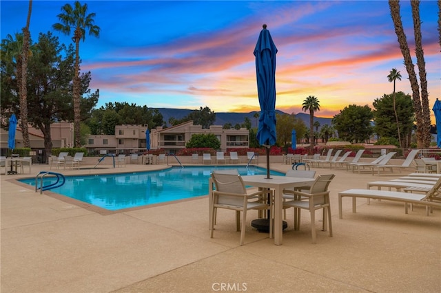 pool at dusk with a patio