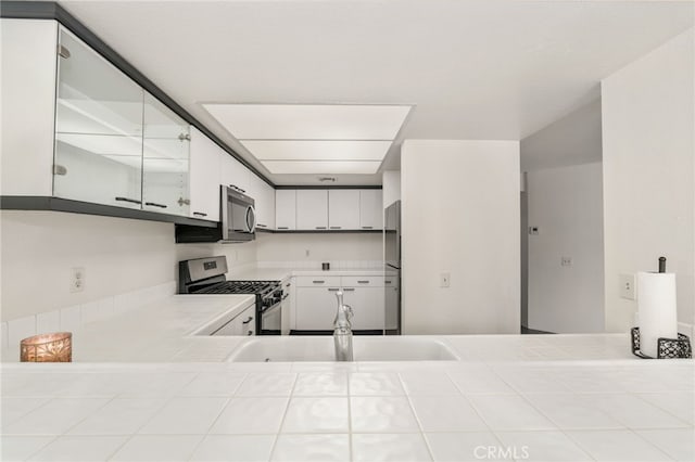 kitchen featuring appliances with stainless steel finishes, sink, and white cabinets