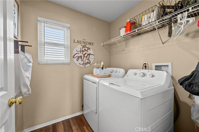 laundry area with washer and dryer and dark wood-type flooring