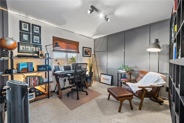 home office with light carpet and a decorative wall