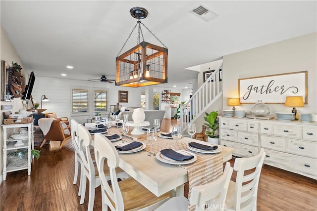 dining room featuring dark hardwood / wood-style flooring and ceiling fan with notable chandelier