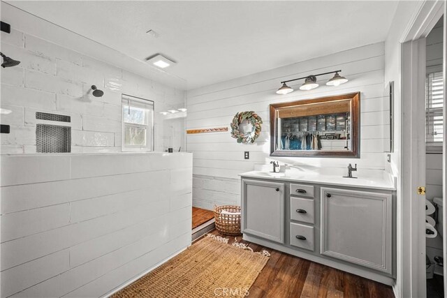 bathroom featuring walk in shower, vanity, and hardwood / wood-style floors