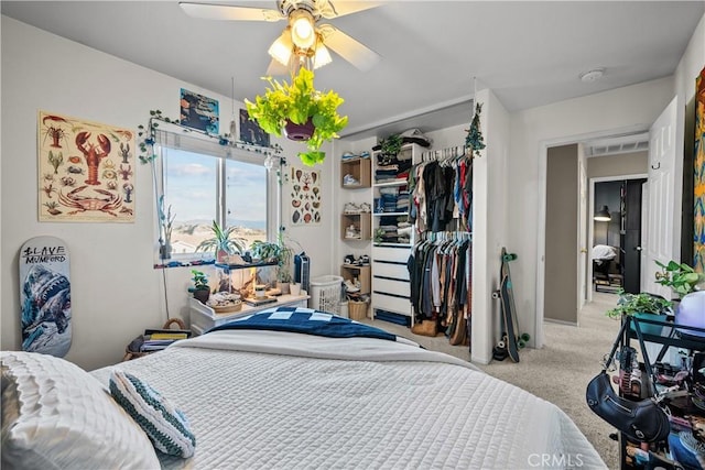 bedroom with a ceiling fan, a closet, and light colored carpet