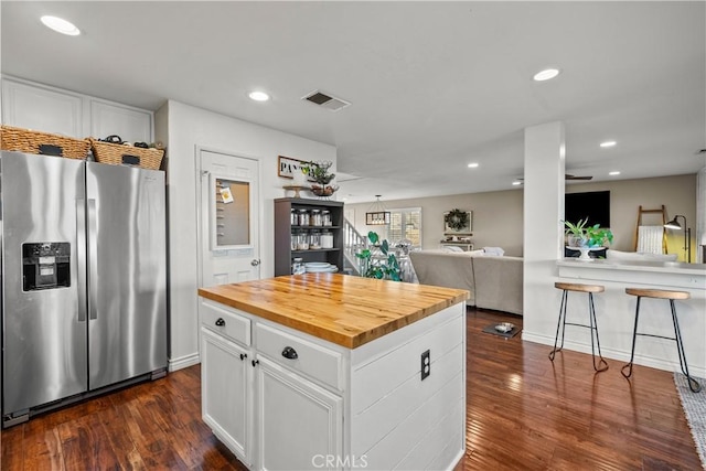 kitchen featuring a center island, open floor plan, white cabinets, and stainless steel refrigerator with ice dispenser