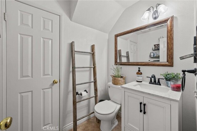 bathroom featuring vanity, lofted ceiling, and toilet