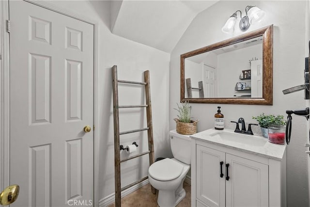 bathroom featuring lofted ceiling, toilet, and vanity