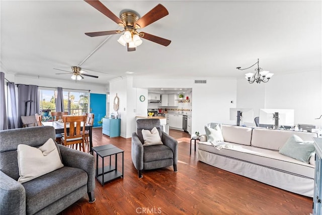 living room with ceiling fan with notable chandelier, dark wood-type flooring, and ornamental molding