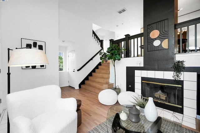 living room with hardwood / wood-style flooring and a tile fireplace