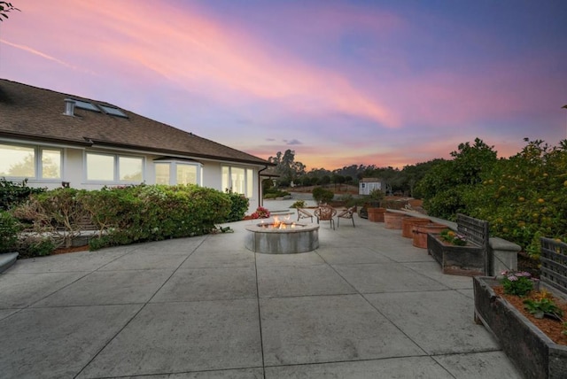 patio terrace at dusk featuring a fire pit