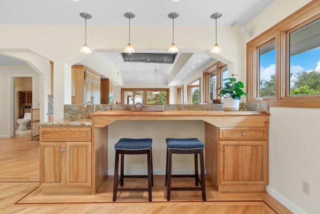 kitchen featuring sink, pendant lighting, a kitchen breakfast bar, and kitchen peninsula