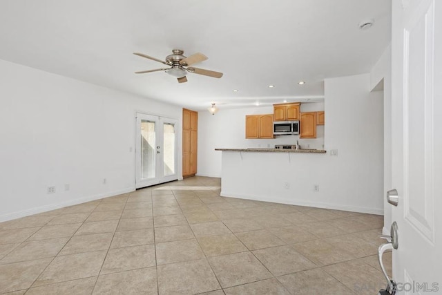 unfurnished living room featuring light tile patterned floors, french doors, and ceiling fan