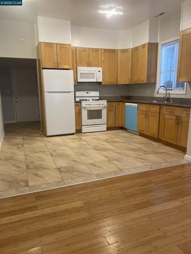 kitchen with sink, white appliances, and light hardwood / wood-style floors