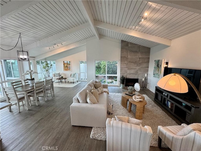 living room featuring high vaulted ceiling, a large fireplace, a chandelier, dark hardwood / wood-style flooring, and beam ceiling