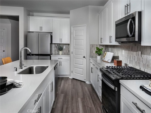 kitchen featuring sink, decorative backsplash, stainless steel appliances, and white cabinets