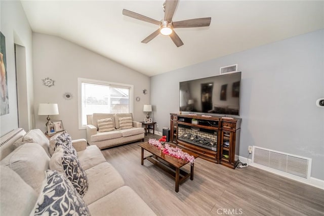 living room with lofted ceiling, hardwood / wood-style floors, and ceiling fan