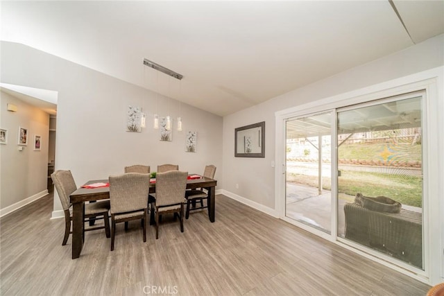 dining area with lofted ceiling and light hardwood / wood-style flooring