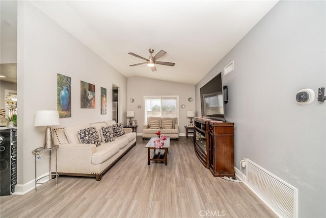 living room featuring ceiling fan, light hardwood / wood-style floors, and vaulted ceiling