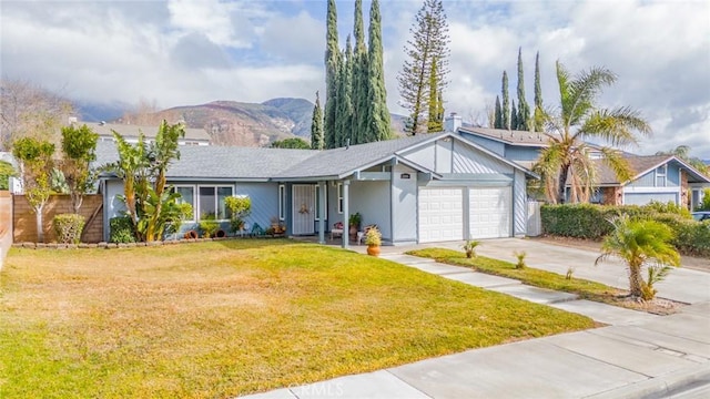 single story home with a mountain view, a garage, and a front lawn