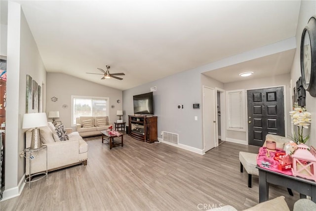 living room featuring light hardwood / wood-style flooring, ceiling fan, and vaulted ceiling