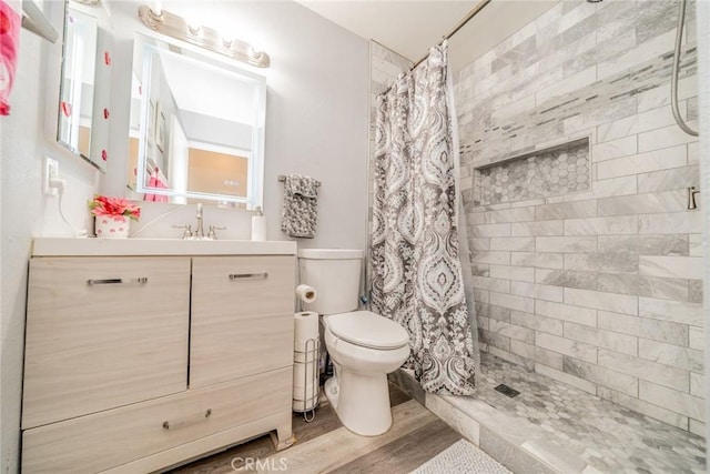 bathroom with vanity, toilet, hardwood / wood-style floors, and walk in shower