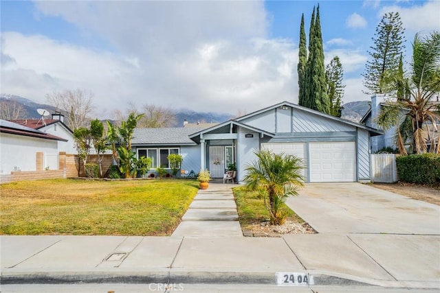 single story home with a mountain view, a garage, and a front yard