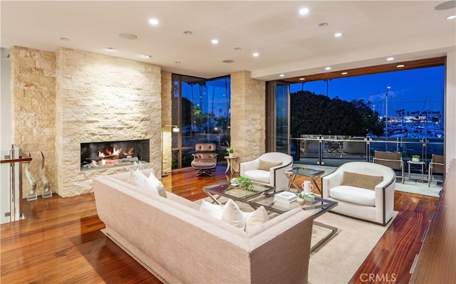 living room featuring hardwood / wood-style flooring, expansive windows, and a fireplace