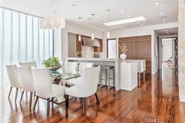 dining area with dark hardwood / wood-style flooring and a skylight